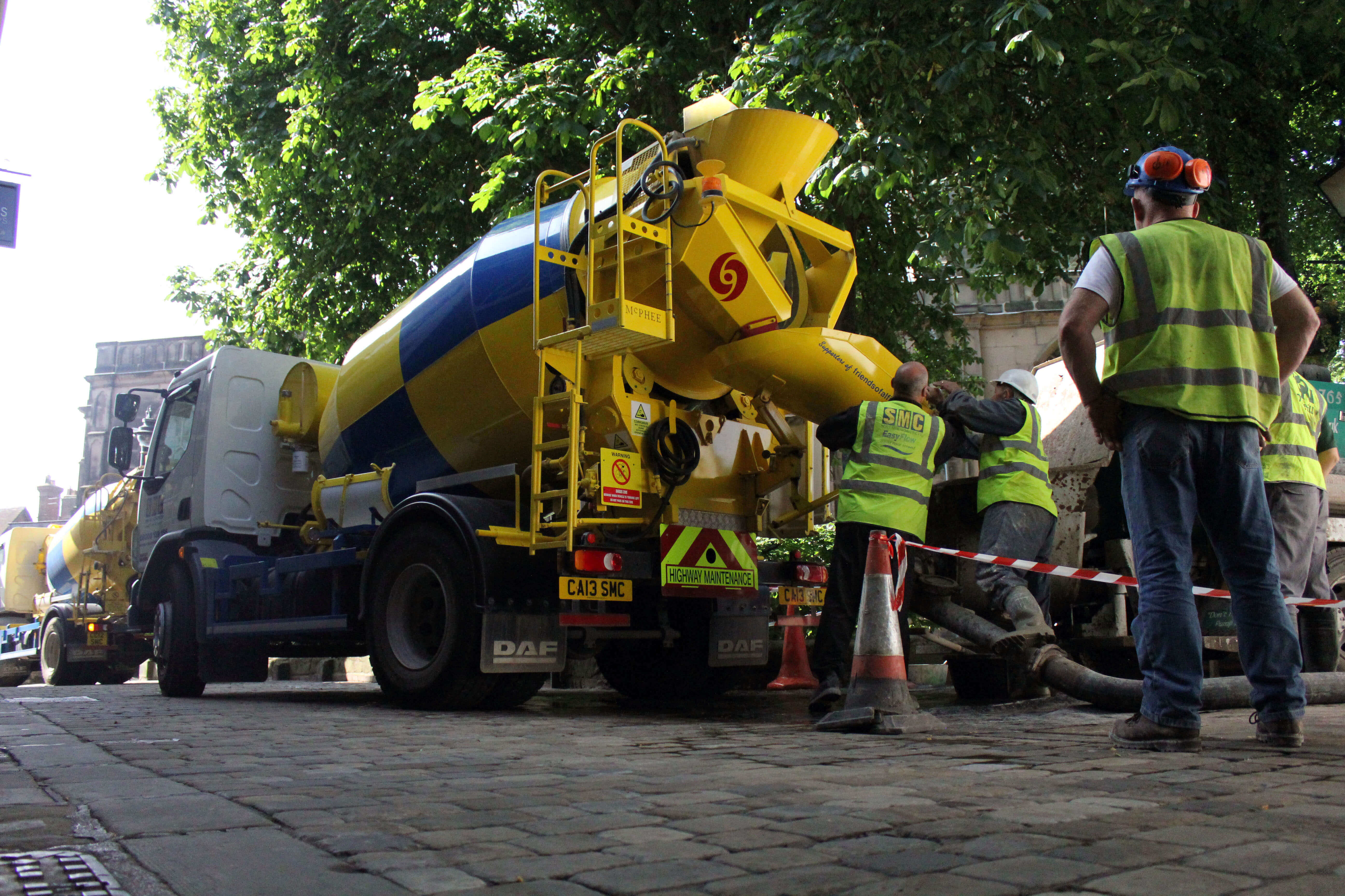 Floor screeding professionals preparing a mixer machine