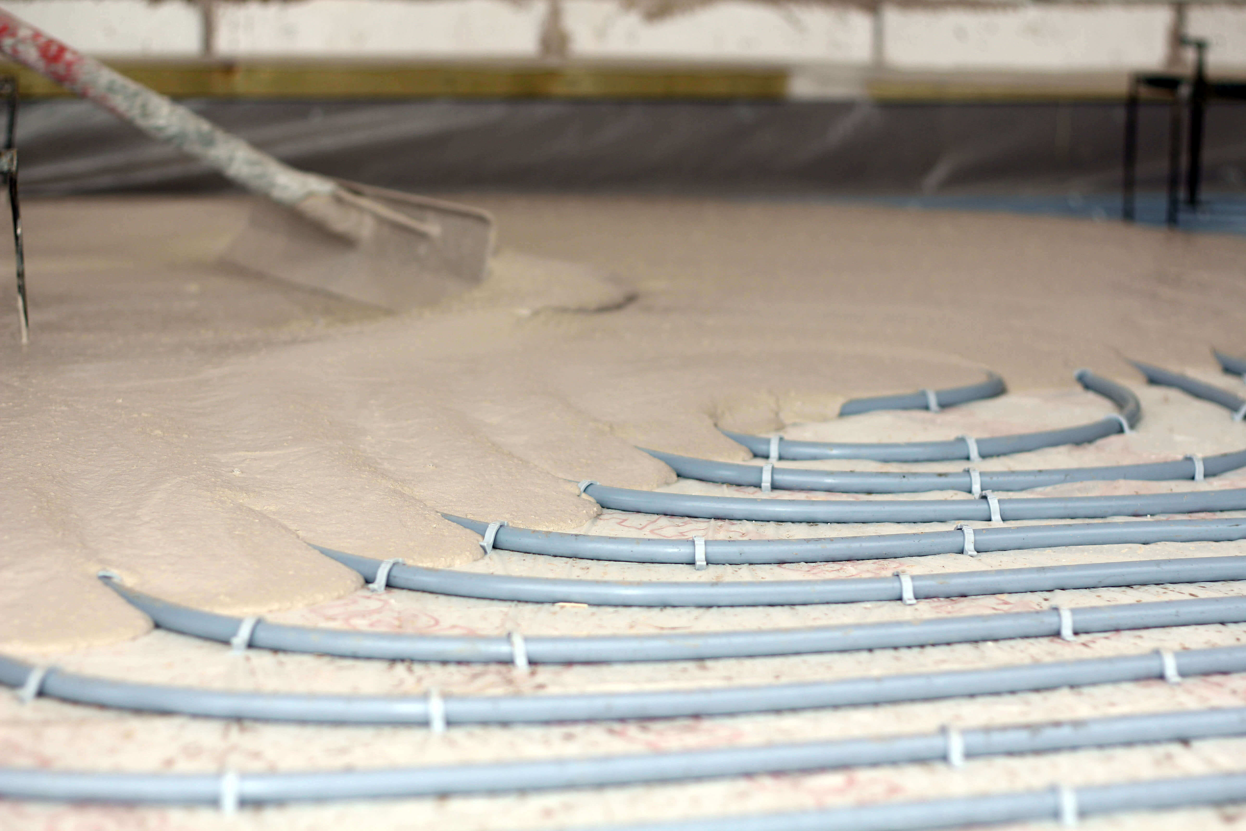 Floor screeding being laid over underfloor heating for wooden flooring