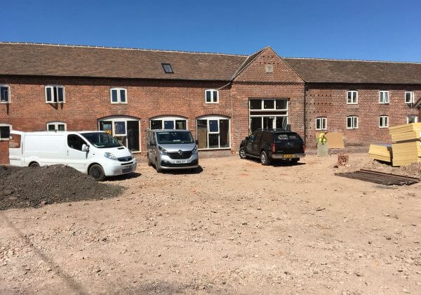 Liquid screed installers parked outside the barn complex in Redhill
