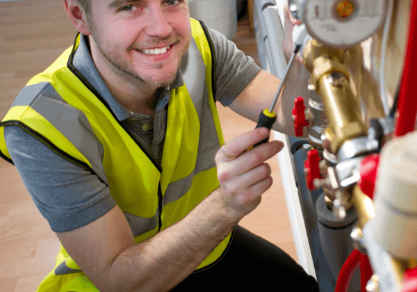 An underfloor heating installation engineer adjusting the manifold