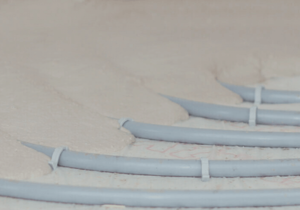 Anhydrite liquid floor screed poured over underfloor heating pipes