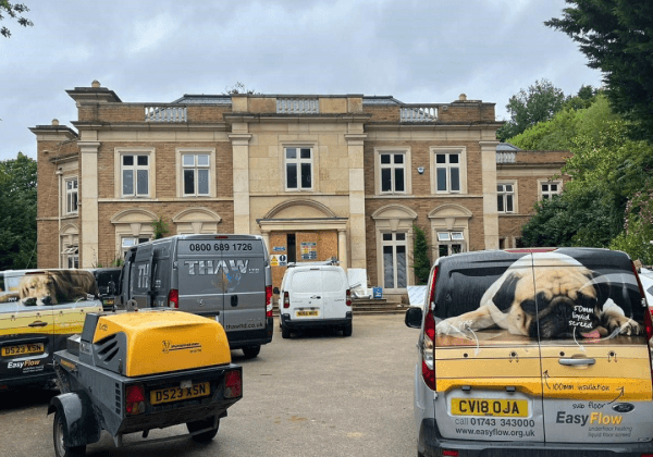 The trucks of the underfloor heating Shropshire team parked outside a commercial property