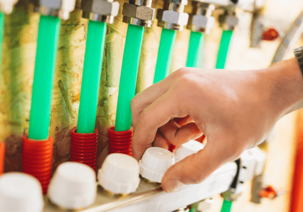 A heating engineer servicing an efficient underfloor heating manifold