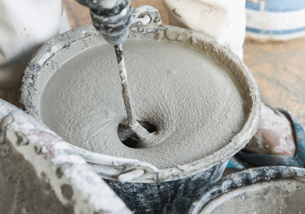 A DIY enthusiast mixing liquid screed in a bucket
