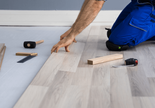 A builder laying wooden floor for underfloor heating
