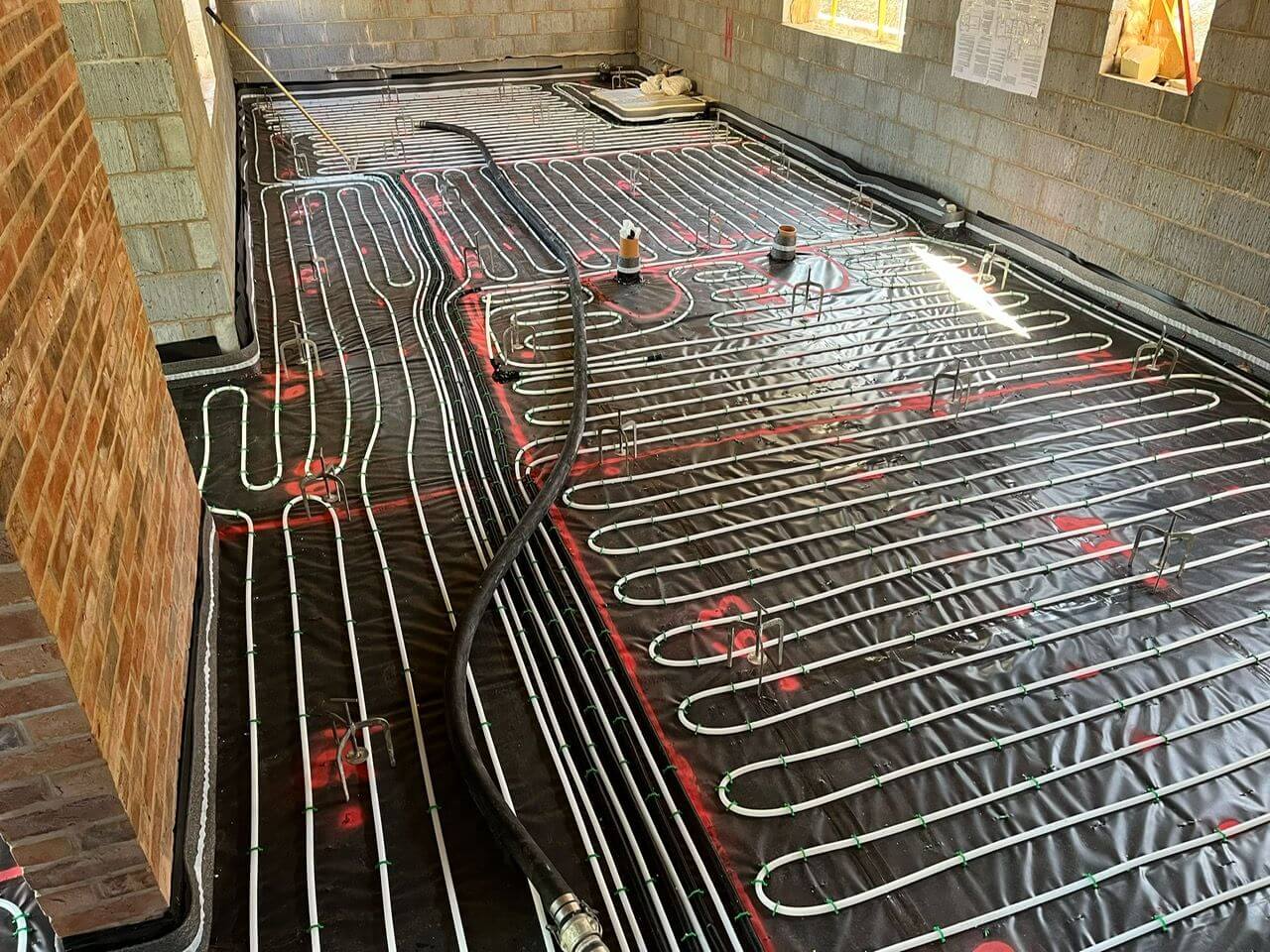 Underfloor heating pipes clipped to the floor