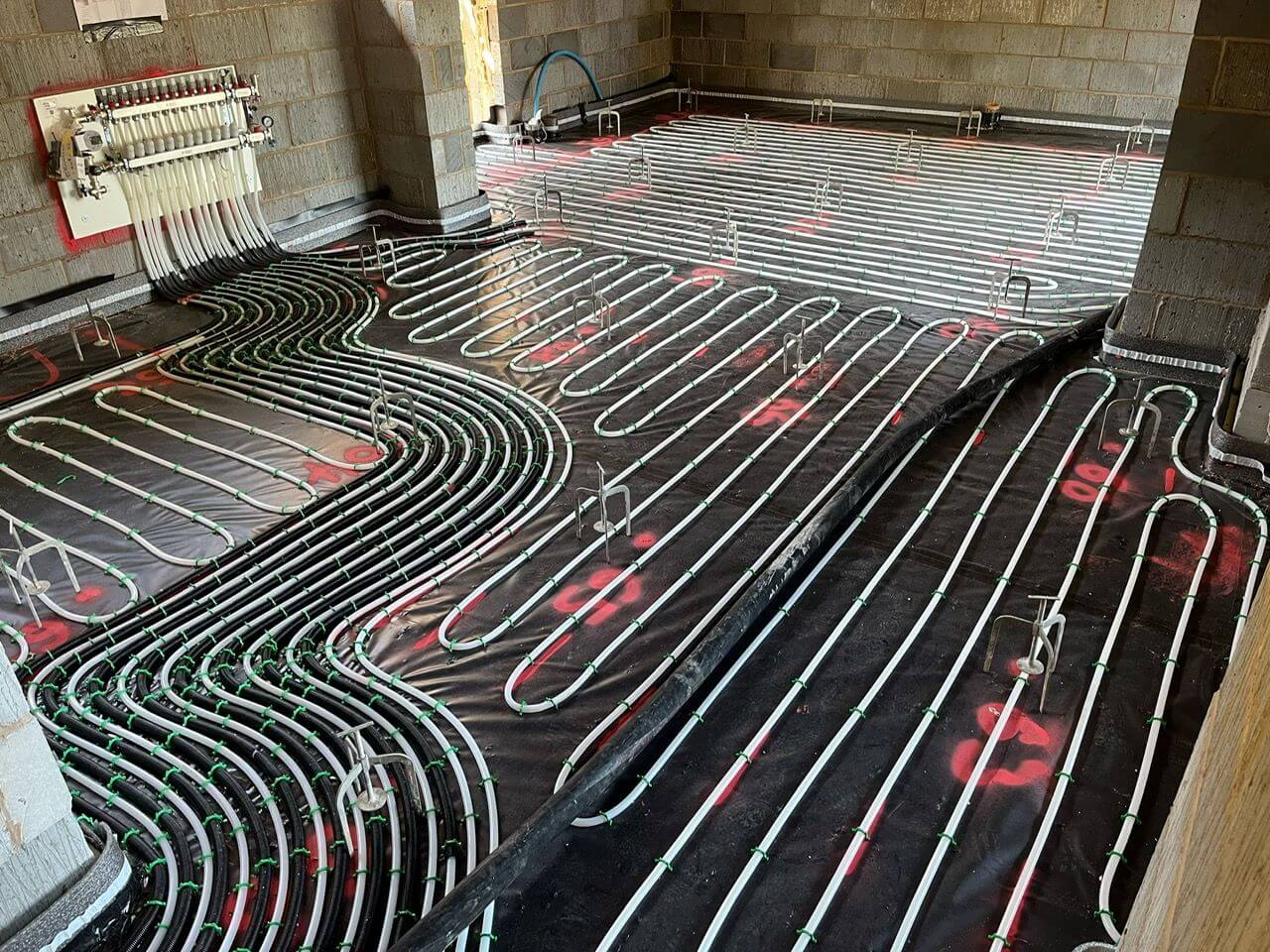 White underfloor heating pipes clipped to the floor