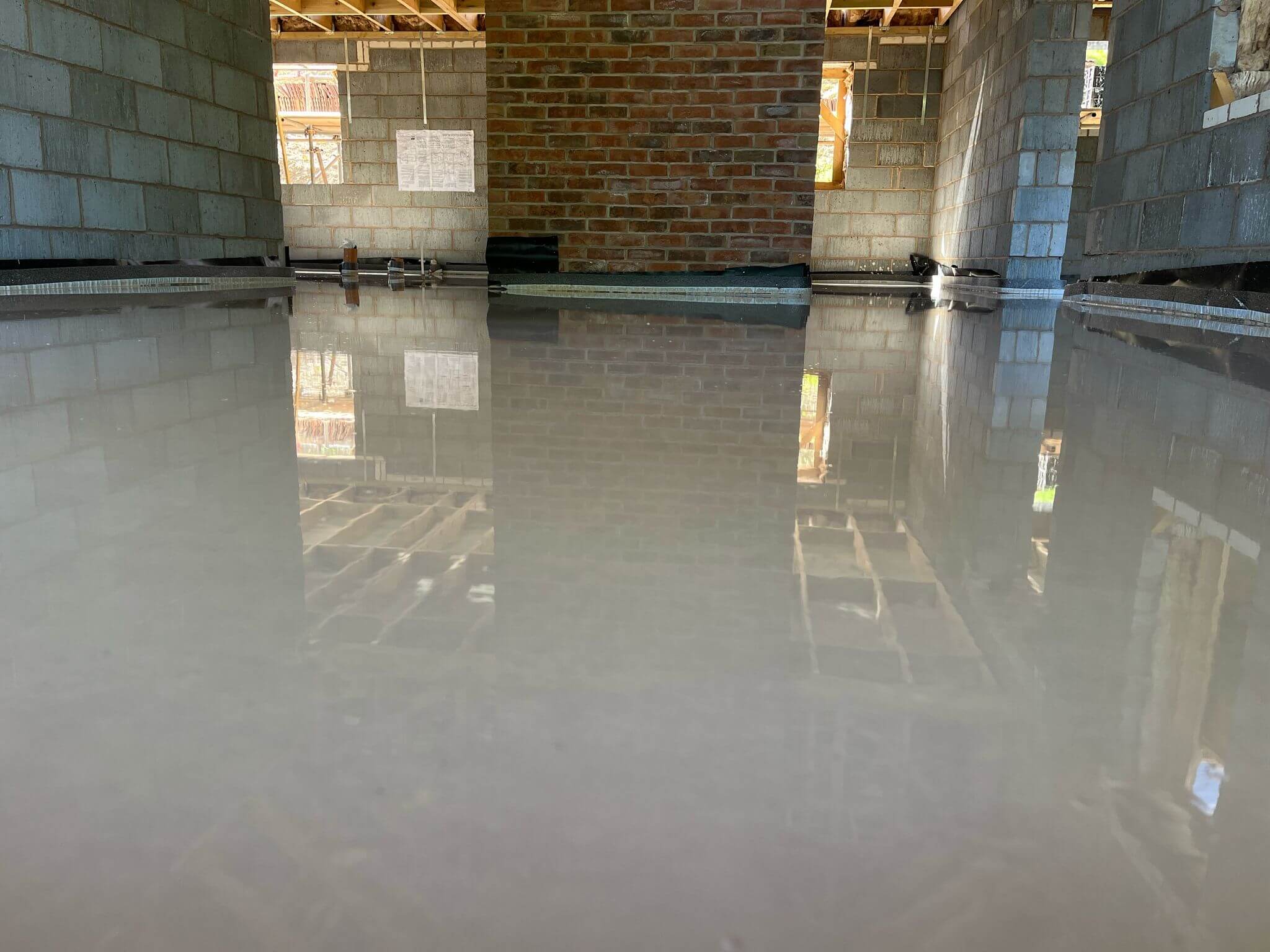 Fresh, shiny liquid screed laid in an open room