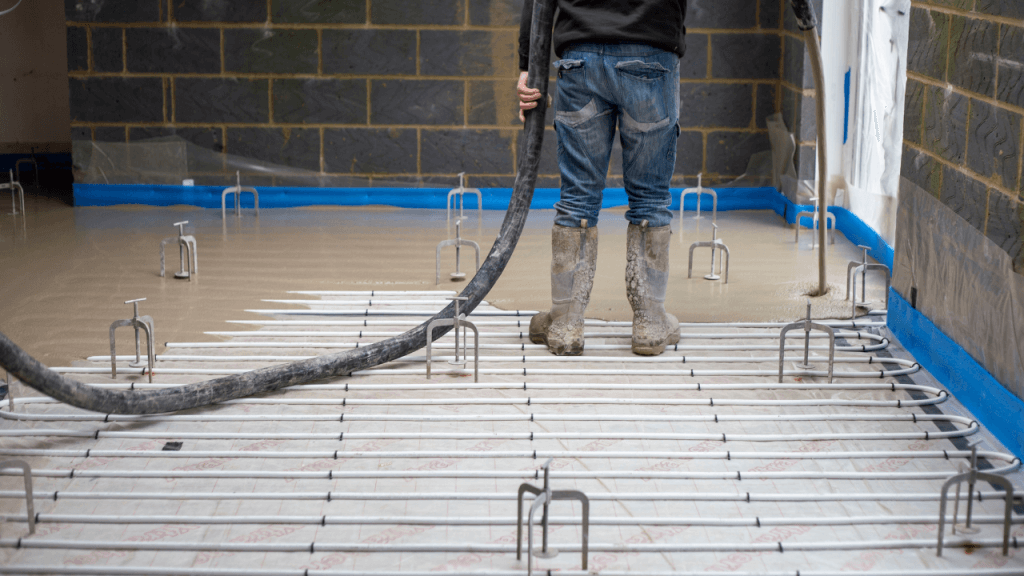 Image of a builder using a moisture meter for screed to force-dry liquid screed. 