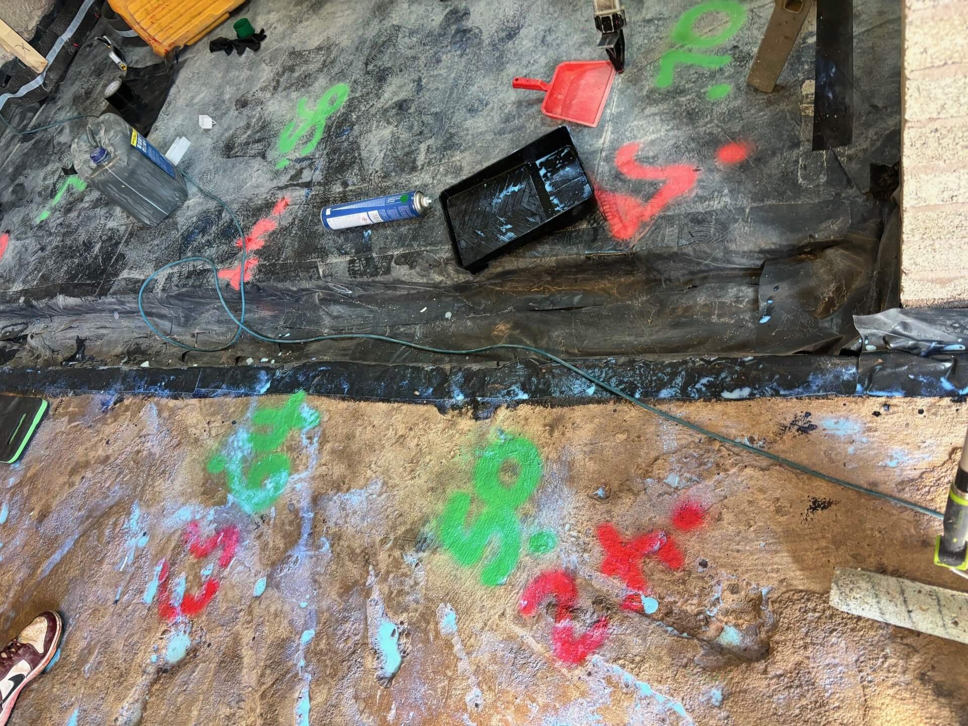 EasyFlow technicians spreading Excelio liquid screed on a primed concrete floor for even coverage