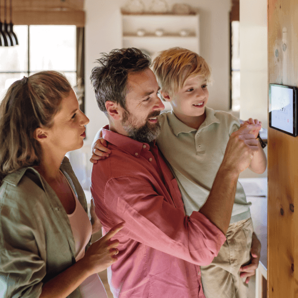 A family changing the settings on their underfloor heating smart hub