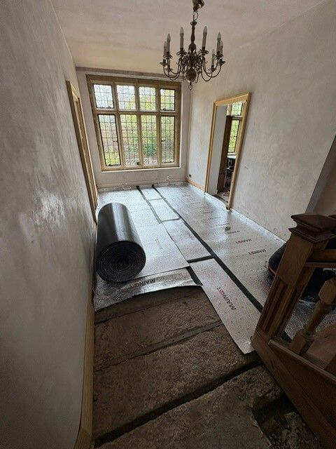 Insulation laid by underfloor heating installer on concrete subfloor