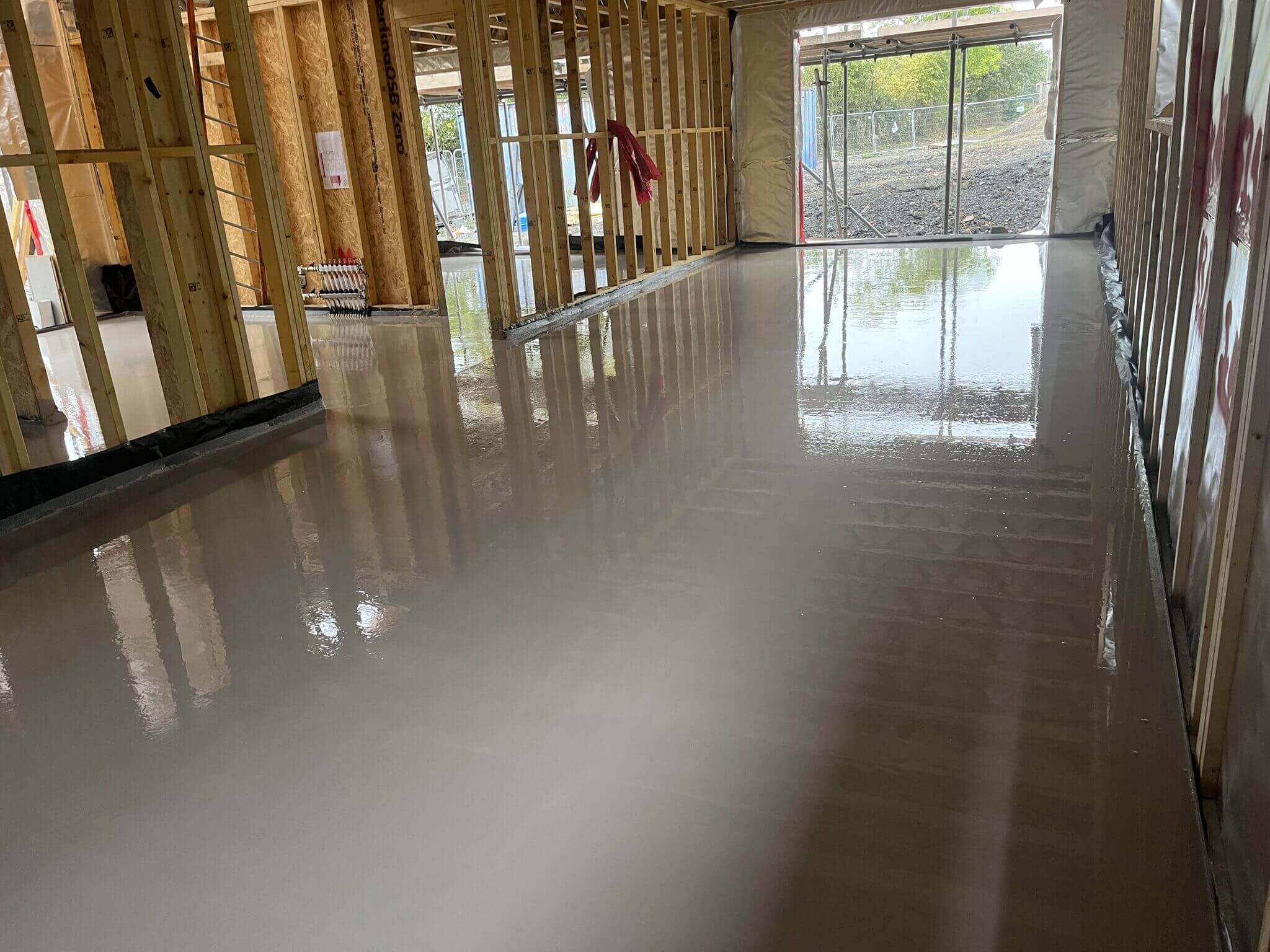 Liquid screed on the ground floor poured by an underfloor heating installer
